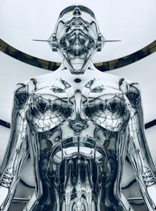 A close-up view of a metallic futurist robot sculpture indoors.